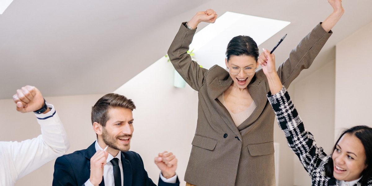 A sales team celebrating a successful quarter, indicative of boosted revenue and growth.