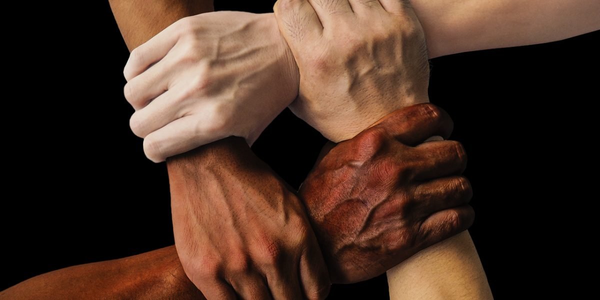 A diverse team engages in collaborative work, reflecting the convergence of different technological domains.
