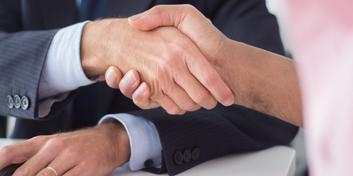 A handshake between professionals symbolizes successful funding rounds and strong investor confidence.