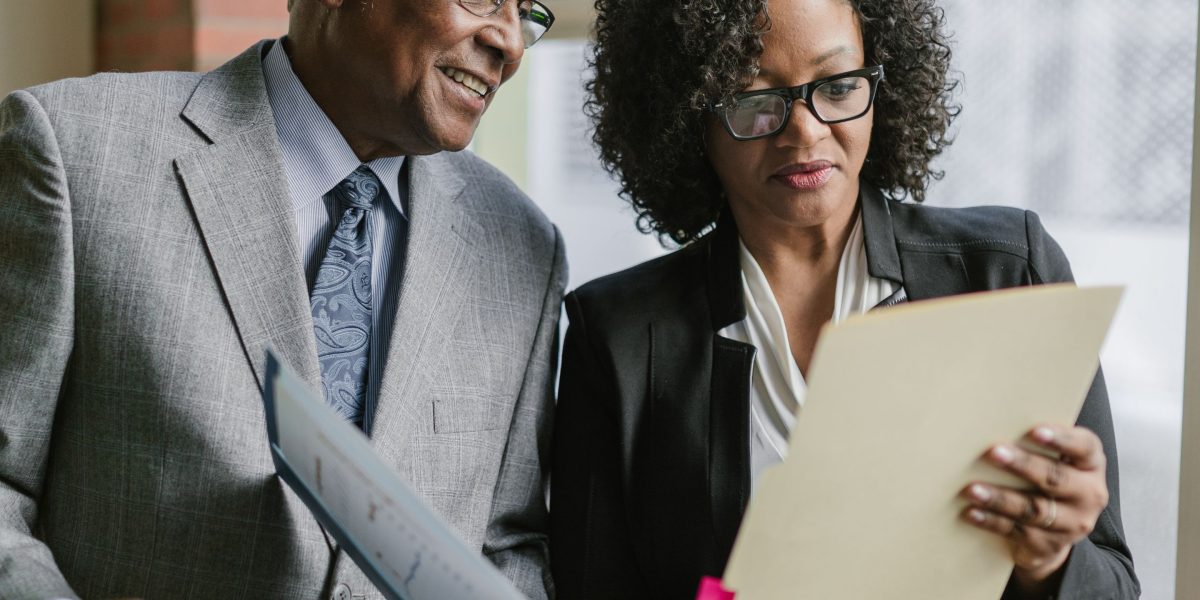 Two professionals meticulously examining documents and reports during a due diligence process.