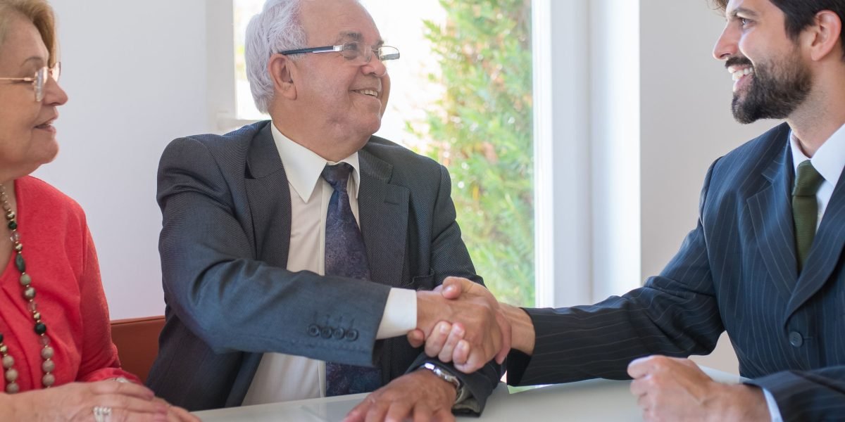 Two business professionals shaking hands, symbolizing successful impact-driven investment.