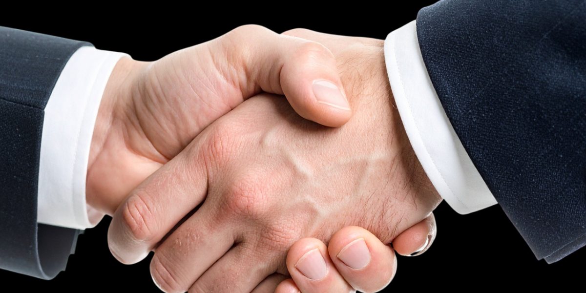 A professional handshake, signifying a completed deal or a strong partnership formed through co-investment.