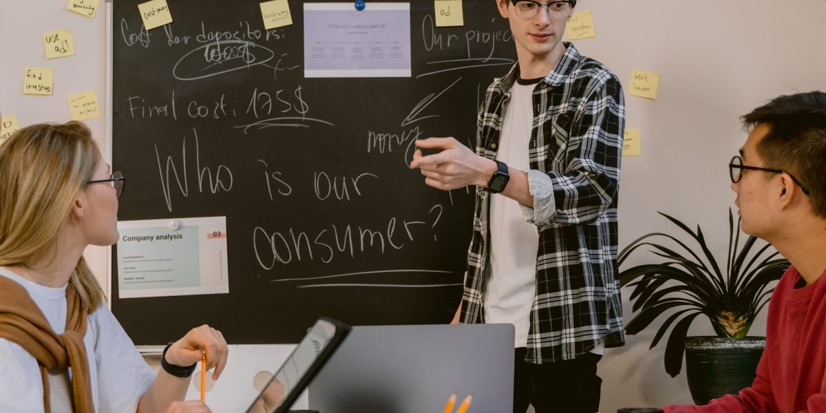 A diverse team collaborates, brainstorming ideas and charting future strategies in a dynamic work environment.