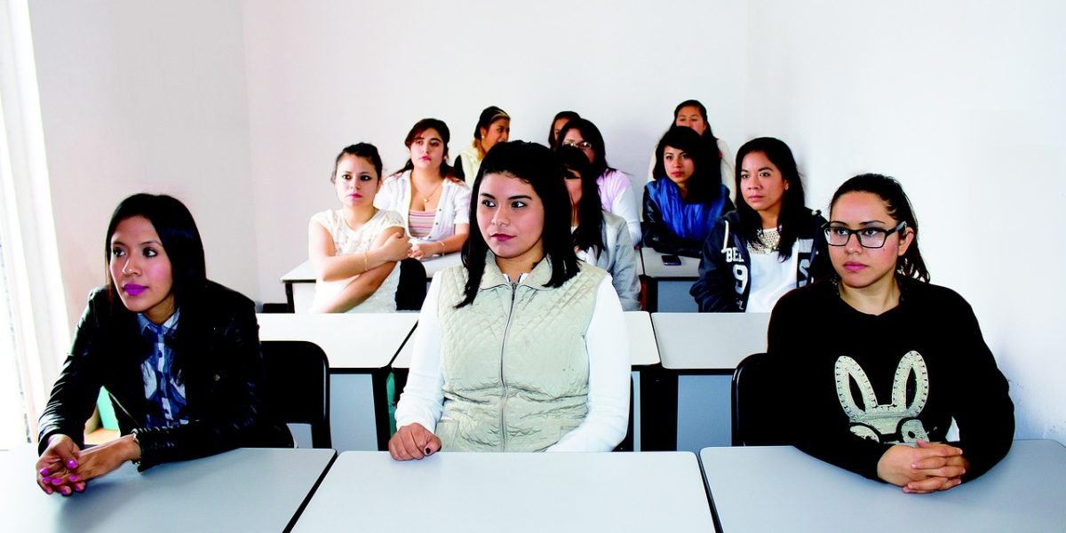 A diverse group of students researching and discussing university choices for computer science programs.