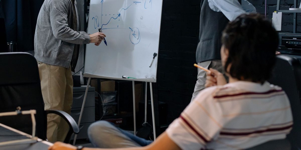 A team actively brainstorming and outlining solutions on a whiteboard, capturing the essence of identifying market needs.
