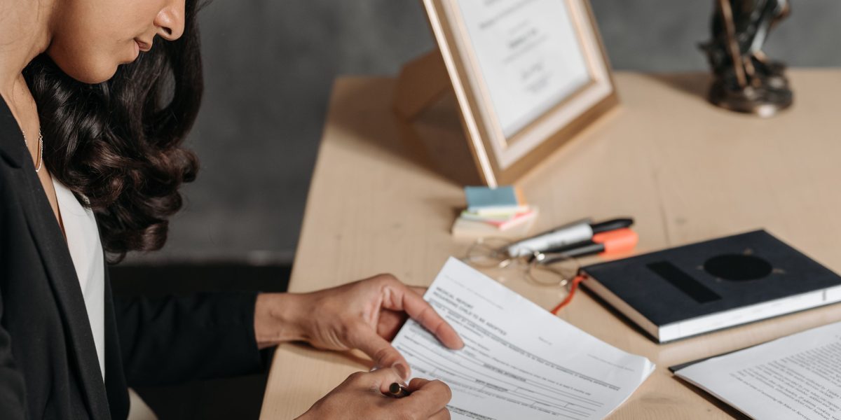 A professional thoughtfully reviewing legal or compliance documents, symbolizing the complexity of global AI regulations.