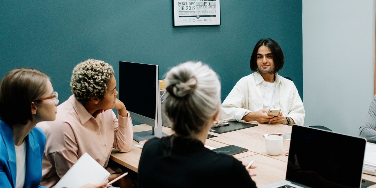 Three professionals in a modern office setting, deep in discussion about future business strategies.