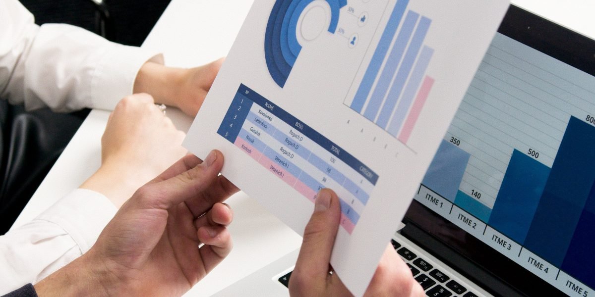 A group of professionals collaborating, discussing charts or data, illustrating the process of identifying market trends.