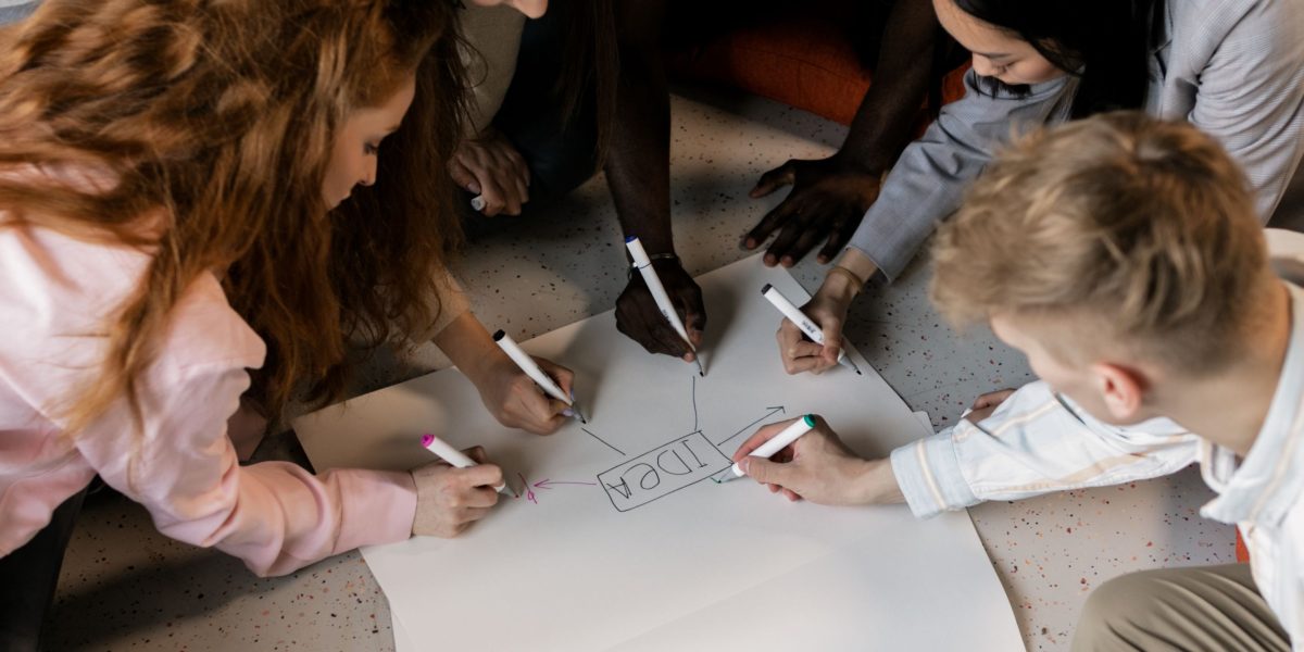A diverse team collaborating around a whiteboard, representing the application of insights into strategic planning.