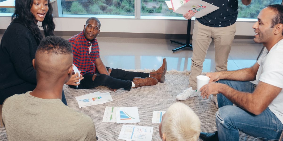 A diverse group of professionals engaged in a thoughtful discussion about future innovations and their potential impact.